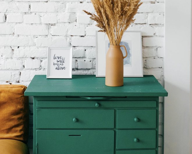 A green desk with a plant.